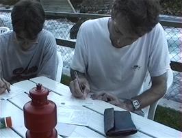Michael and Graham enjoy writing postcards home beside the river at Skjolden youth hostel